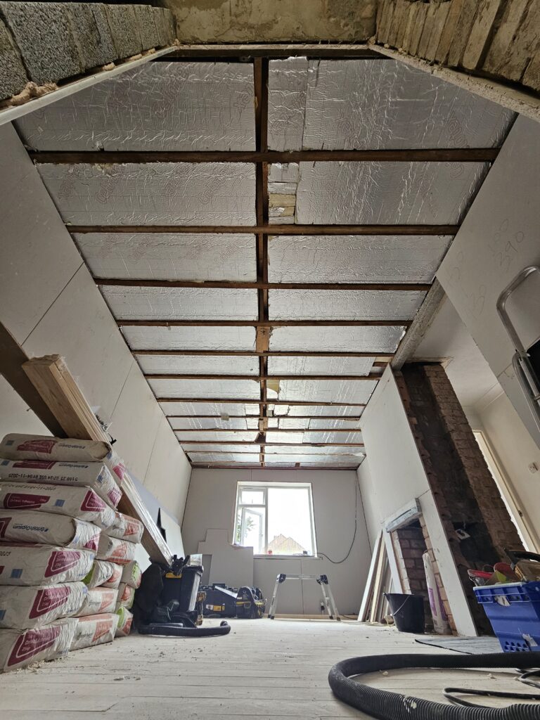 Installation of Celotex PIR rigid foam insulation boards between ceiling joists by Renofox Construction.